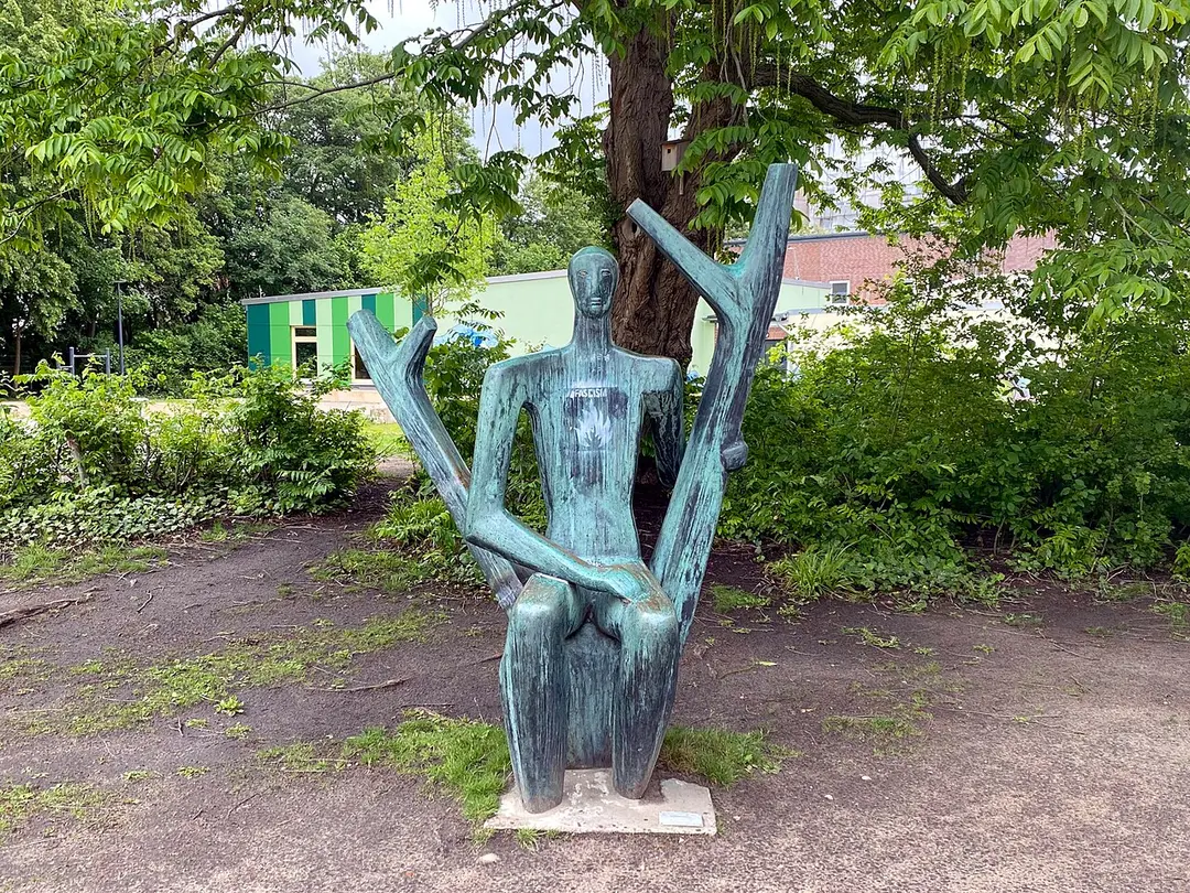 Männliche Figur im Doppelstamm